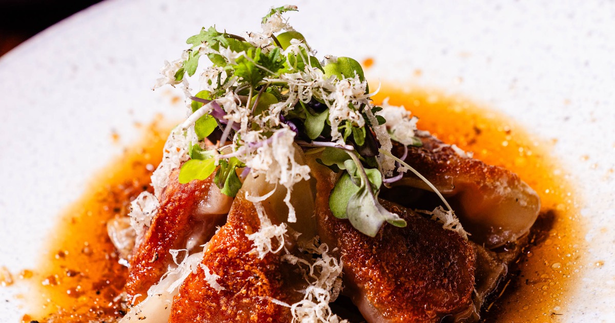 Pan-fried pork gyoza dumplings served in a savory sauce