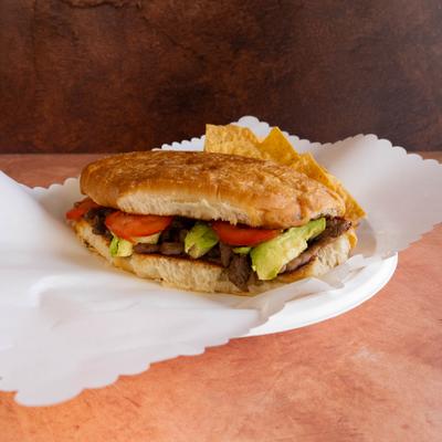 Steak sandwich with tomatoes and avocado.