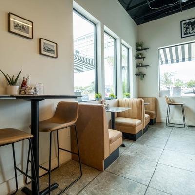 Small tables for two lined up against the wall.