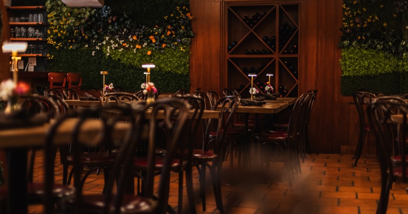 Elegant dining room with wooden chairs, wine rack, and soft ambient lighting