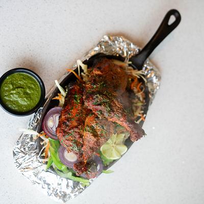 Tandoori Chicken and green chutney on the side, top view.