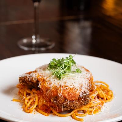 Chicken parmesan served with spaghetti.