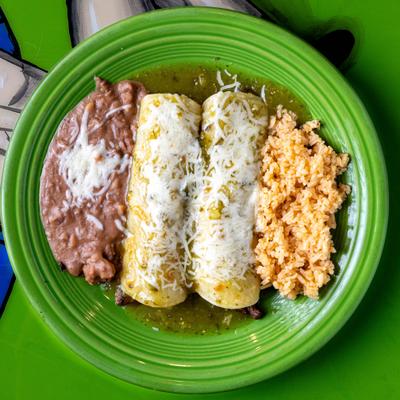 Enchiladas with rice and refried beans on a green plate.