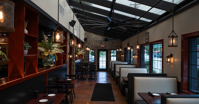 Interior seating area with chairs, tables, booths and hanging lanterns