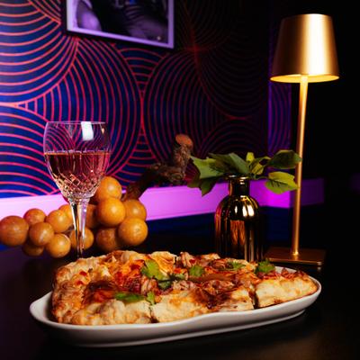 BBQ chicken flatbread served with a glass of rose wine.