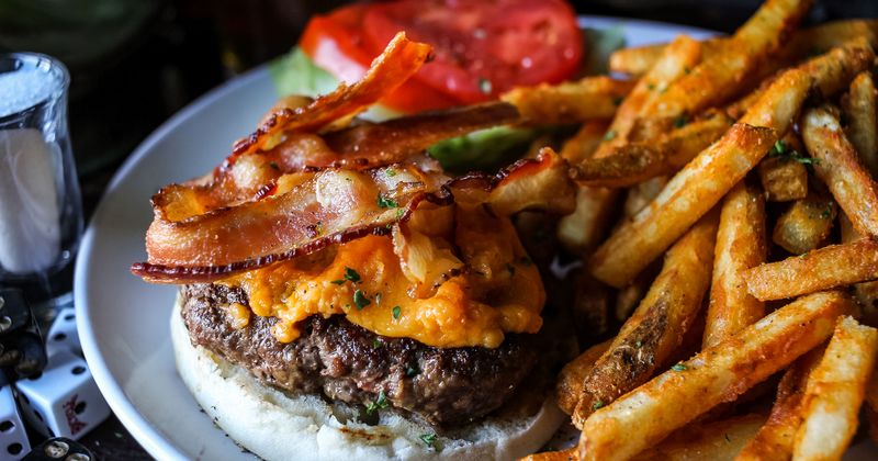 Burger with meat, cheese and bacon, fries on the side