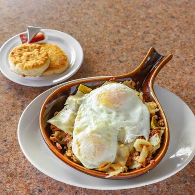 Skillet with eggs and a side biscuit.