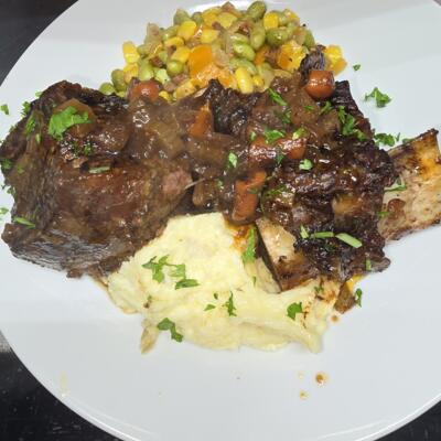 Braised beef with mashed potatoes and vegetables.