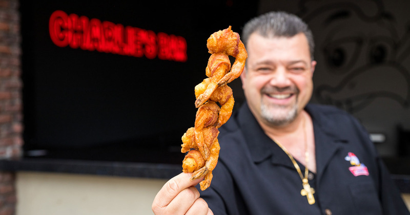 Owner holding a shrimp skewer in the foreground