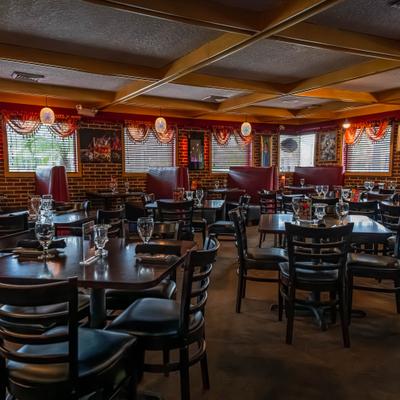 Dining area with set tables, chairs, and red booths.