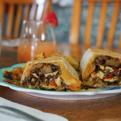 Smoked Brisket Burrito with a cocktail in the background.