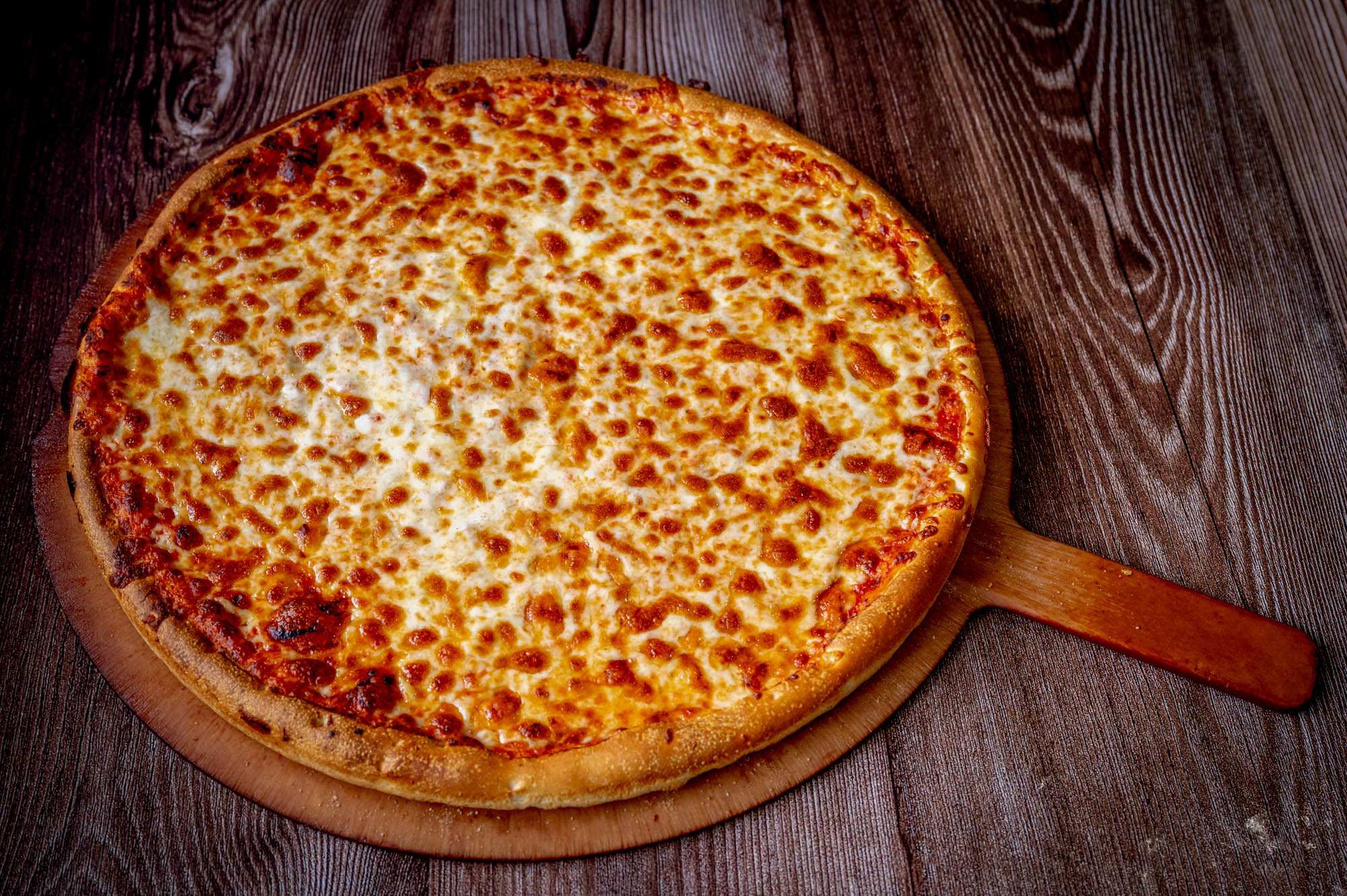 Cheese pizza on a wooden peel