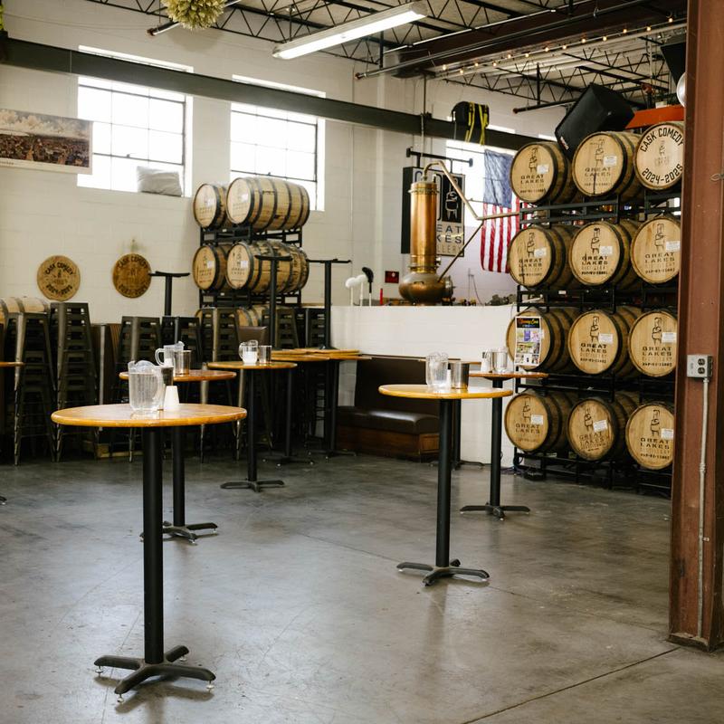 Interior, production floor, high wooden top tables, wooden barrels in the back