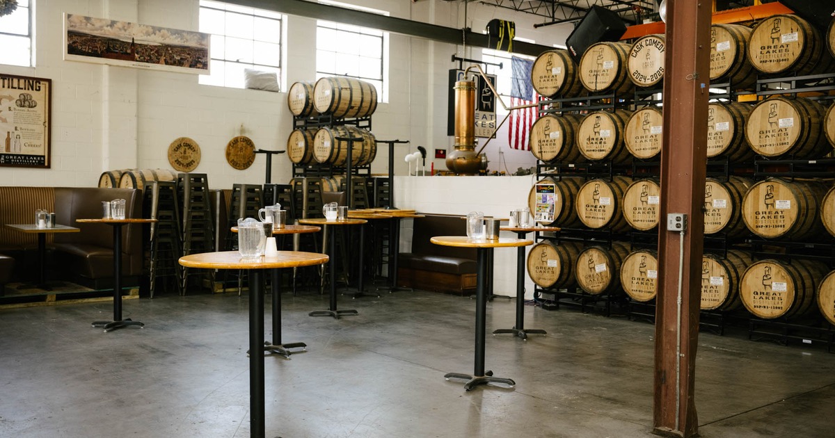 Interior, production floor, high wooden top tables, wooden barrels in the back