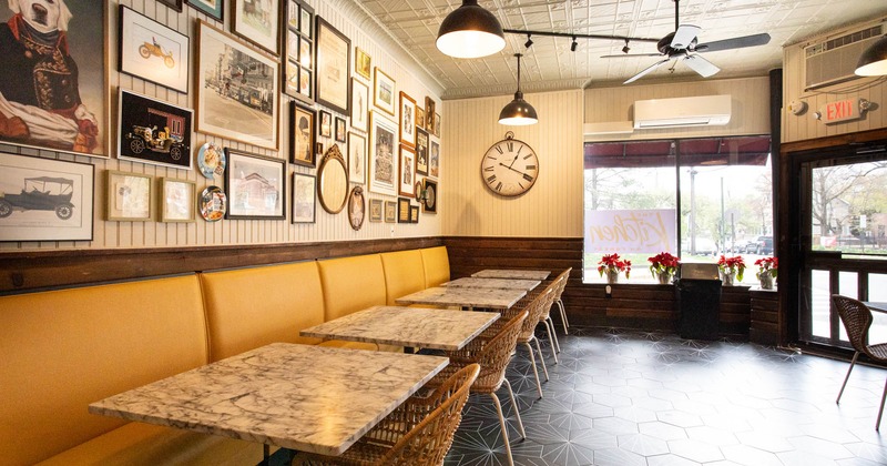 Decorated interior, banquette seating and tables by a wall