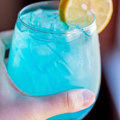 Hand holdng a glass of Dirty Lavender Lemonade.