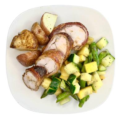 Bacon-wrapped chicken with roasted vegetables.