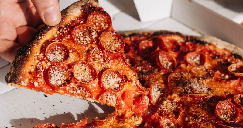 Hand holding L'il Roni slice of pizza