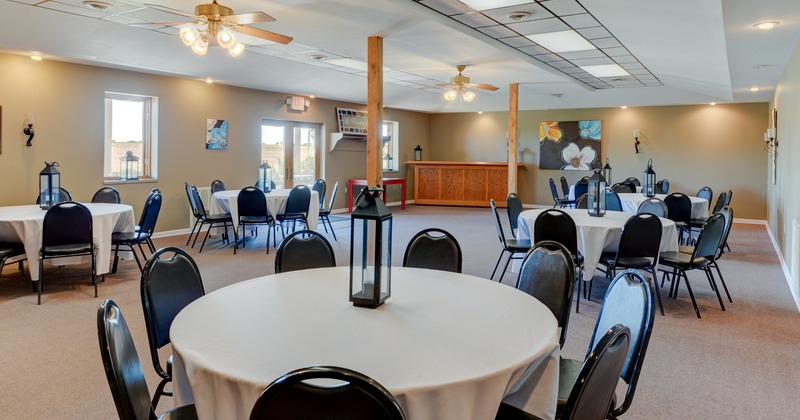 Banquet interior, round tables with lanterns on them and chairs