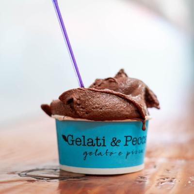 A scoop of chocolate gelato in a blue cup.