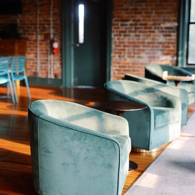 Sunlit lounge area with teal chairs.