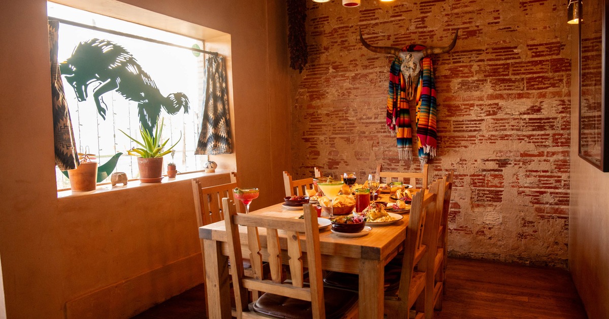 Rustic dining room with a wooden table set with drinks and food