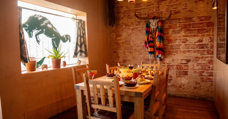Rustic dining room with a wooden table set with drinks and food