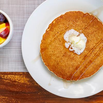 Pancakes with butter and a side of fruit.