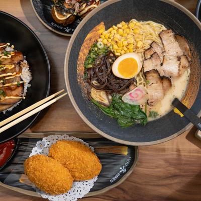 Assorted Japanese dishes including ramen and mashed potato croquettes on a table.