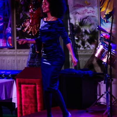 Live music moment with singer in front of colorful paintings in the background.