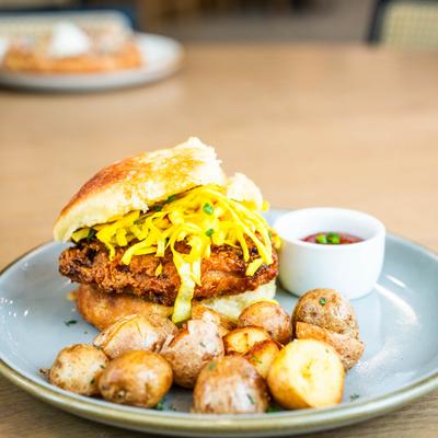 Nashville deluxe sandwich served with roasted potatoes and a dipping sauce.