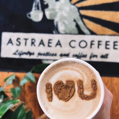 A latte with I Love You latte art with a branded placemat in the background.