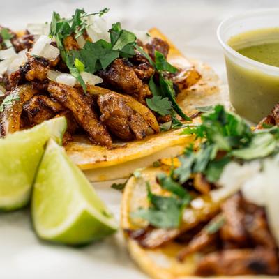 Taco al pastor with cilantro, onions, green salsa and lime.