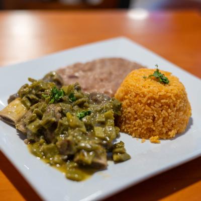 Pork in green sauce, served with rice and refried beans.