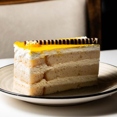 Slice of layered cake topped with yellow frosting.