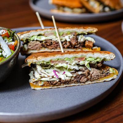 Smoked brisket torta with coleslaw and avocado.