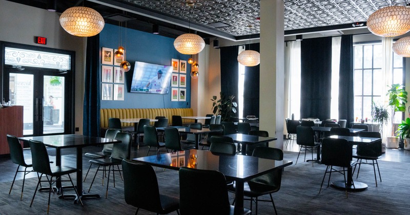 Interior, dining area, restaurant entrance, tables for four and two, carpet flooring