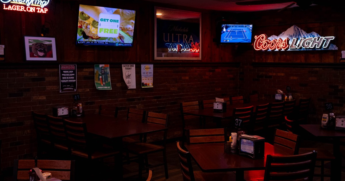 Covered seating area, dark ambient with neon wall decor and posters