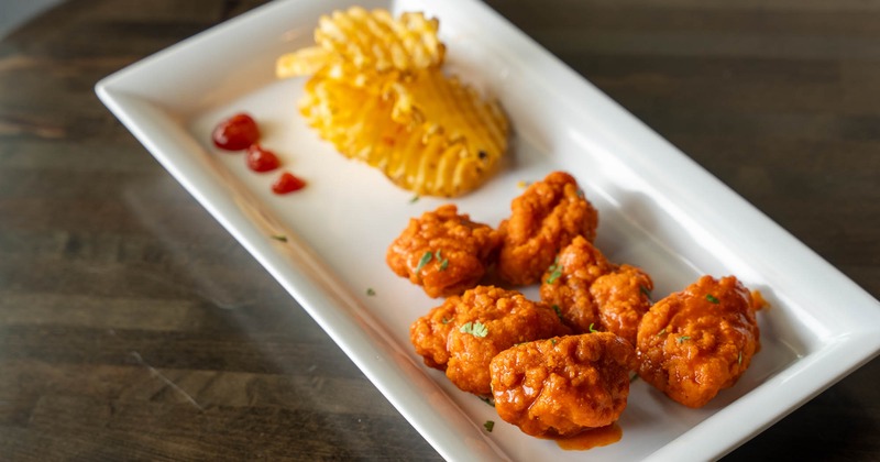 Boneless buffalo wings and waffle fries