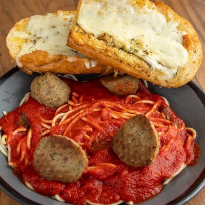 Spaghetti and Meatballs served with two pieces of cheesy garlic bread.