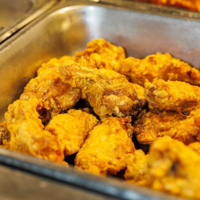 Fried chicken wings in a metal tray.