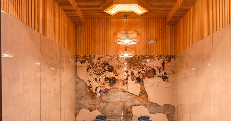Private dining room with wood paneling and a marble accent wall