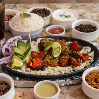 Chicken tikka with side dishes.