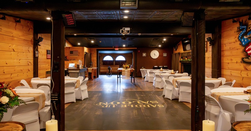 Interior, open space event room, round tables for eight, exposed wooden beams
