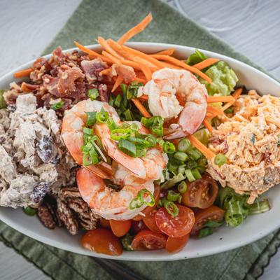 Salad with mixed greens, bacon, pimento cheese, chicken salad, shrimp, and veggies.