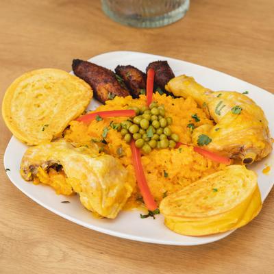 Marinated chicken with yellow rice, green peas, and plantains.