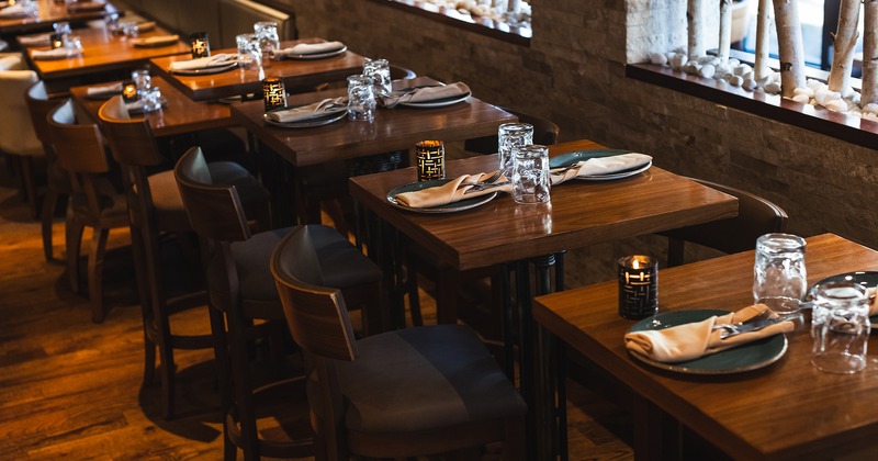 Restaurant interior, dining tables set for two guests, lined up