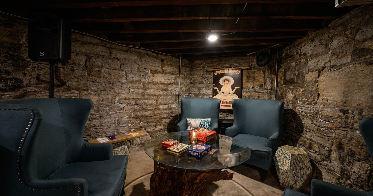 Interior, seating area, tall armchairs with glass top coffee table, stone walls