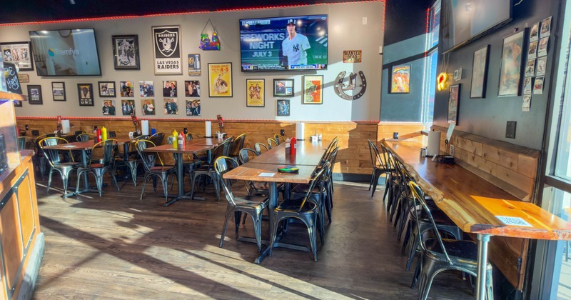 Interior, casual dining restaurant with wooden flooring, black metal chairs, and wooden tables