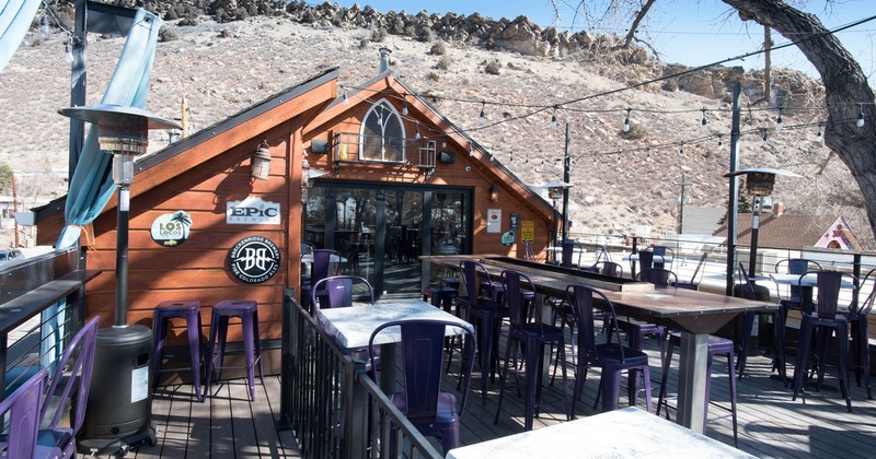 Exterior decorated with beer stickers and seating area in patio